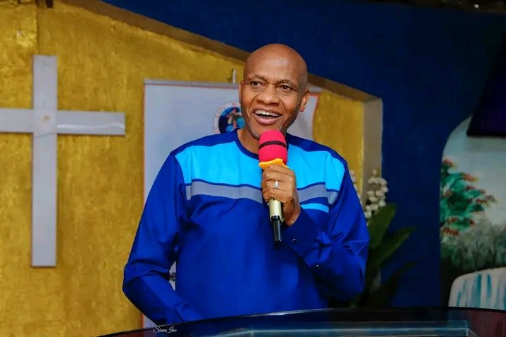 Bishop John Kaberere in a blue tunic ministering