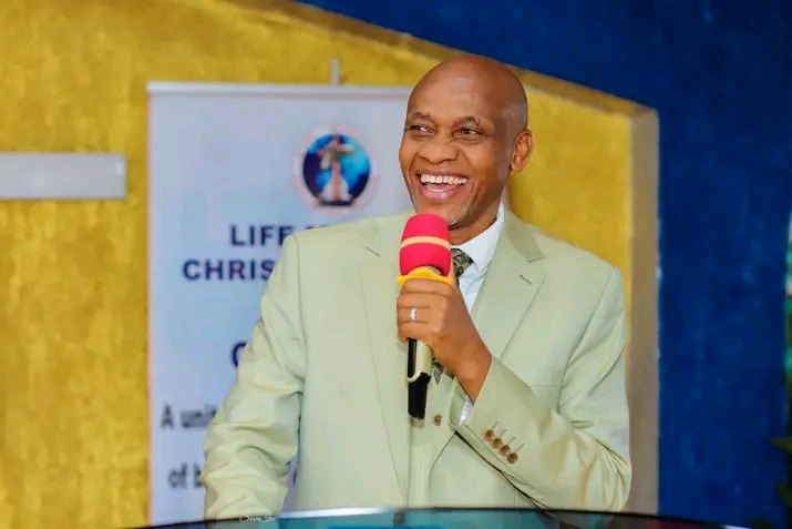 Bishop John Kaberere laughing while ministering