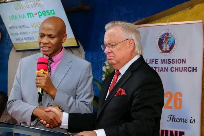 Bishop John Kaberere shaking hands with a friend of the church