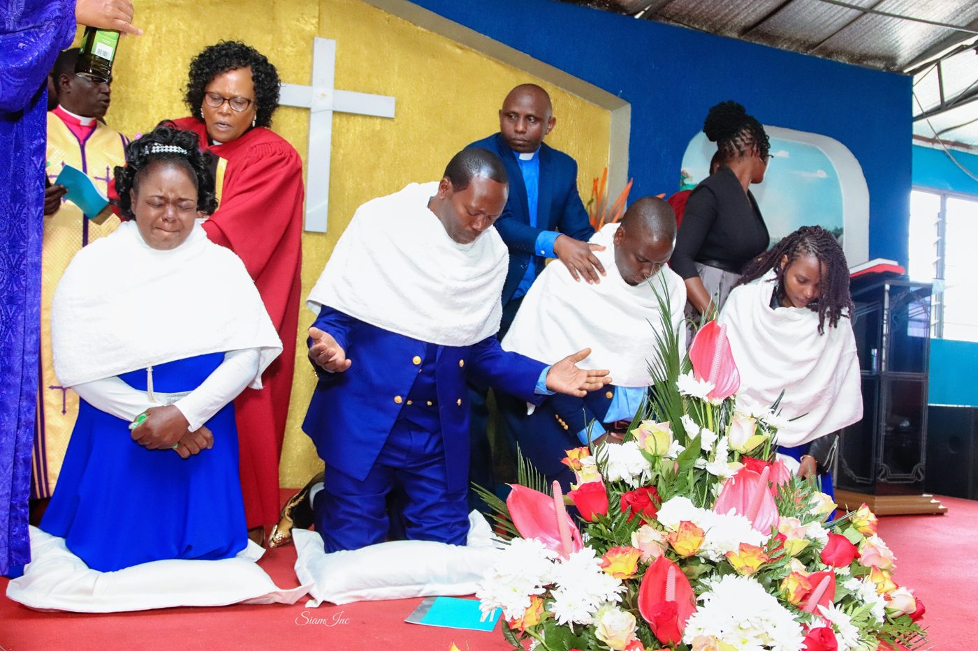 Ministers praying over newly ordained pastors