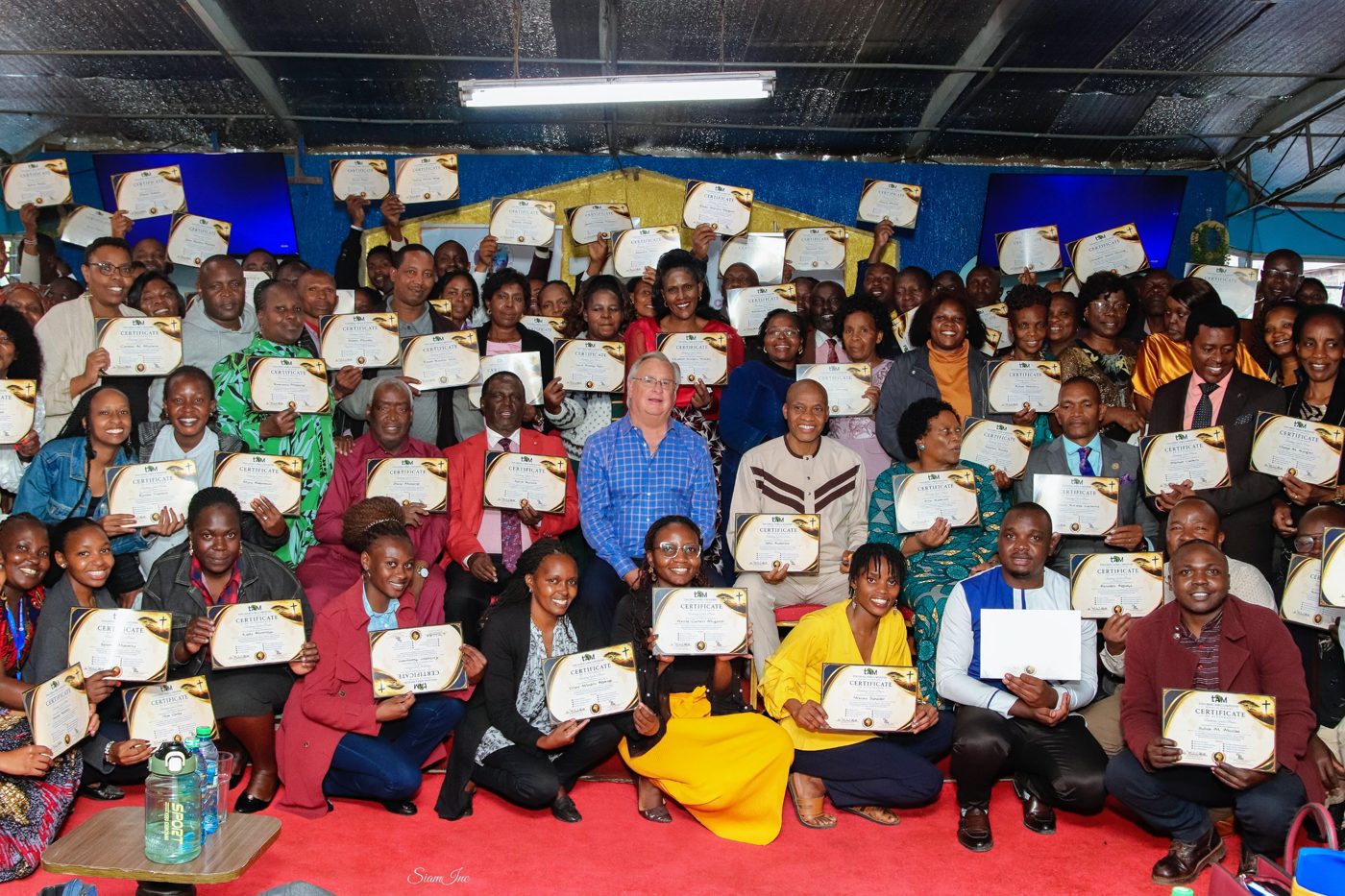 Graduates of the Touching Africa Ministries training holding certificates