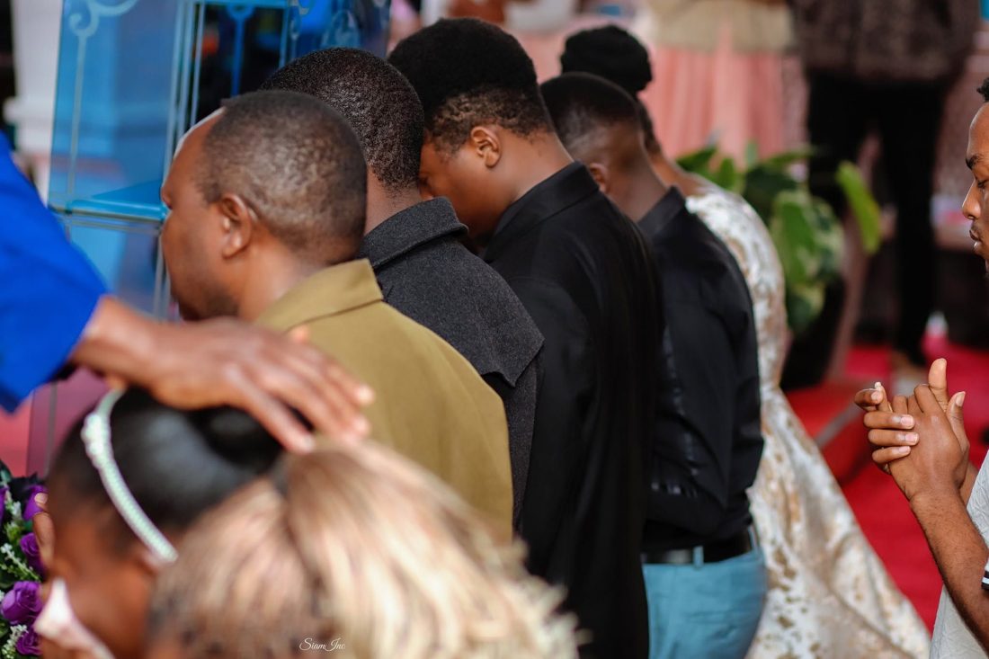 A hand laid in prayer over a worshipper